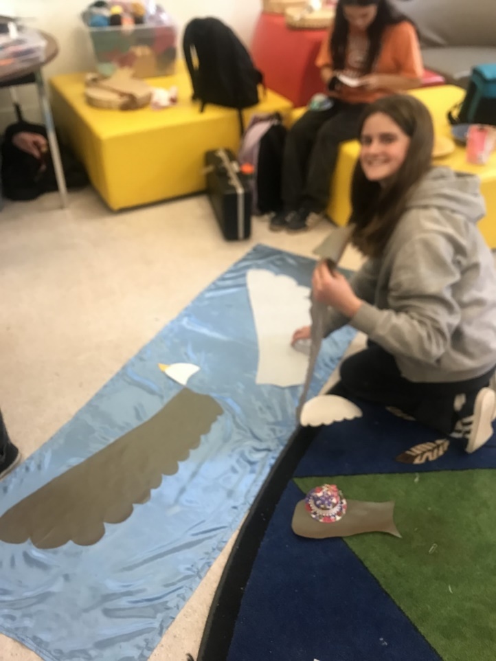 A person sitting on the floor with a blue blanket
Description automatically generated