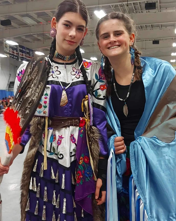 Two women in traditional clothing
Description automatically generated