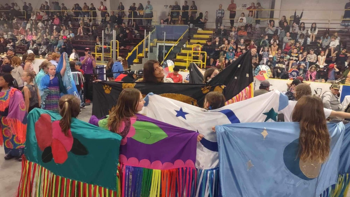 A group of people holding flags
Description automatically generated