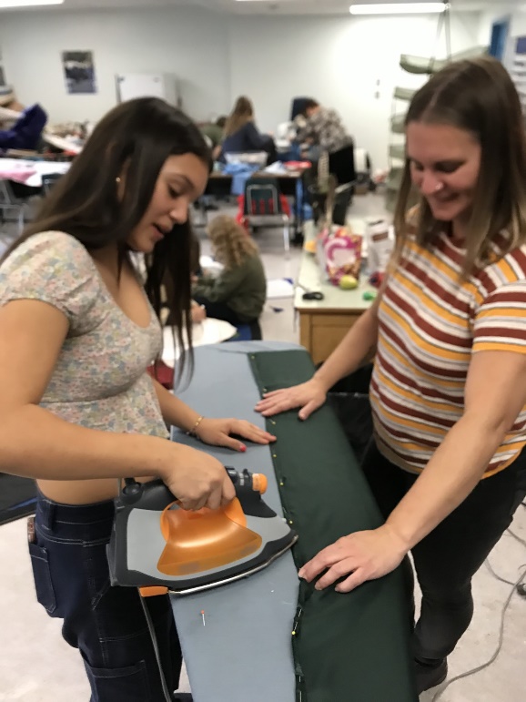 A person ironing a piece of fabric
Description automatically generated