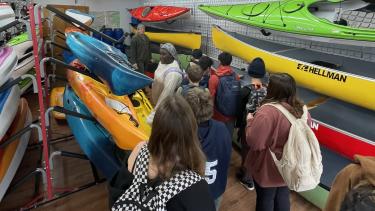 Students looking at canoes