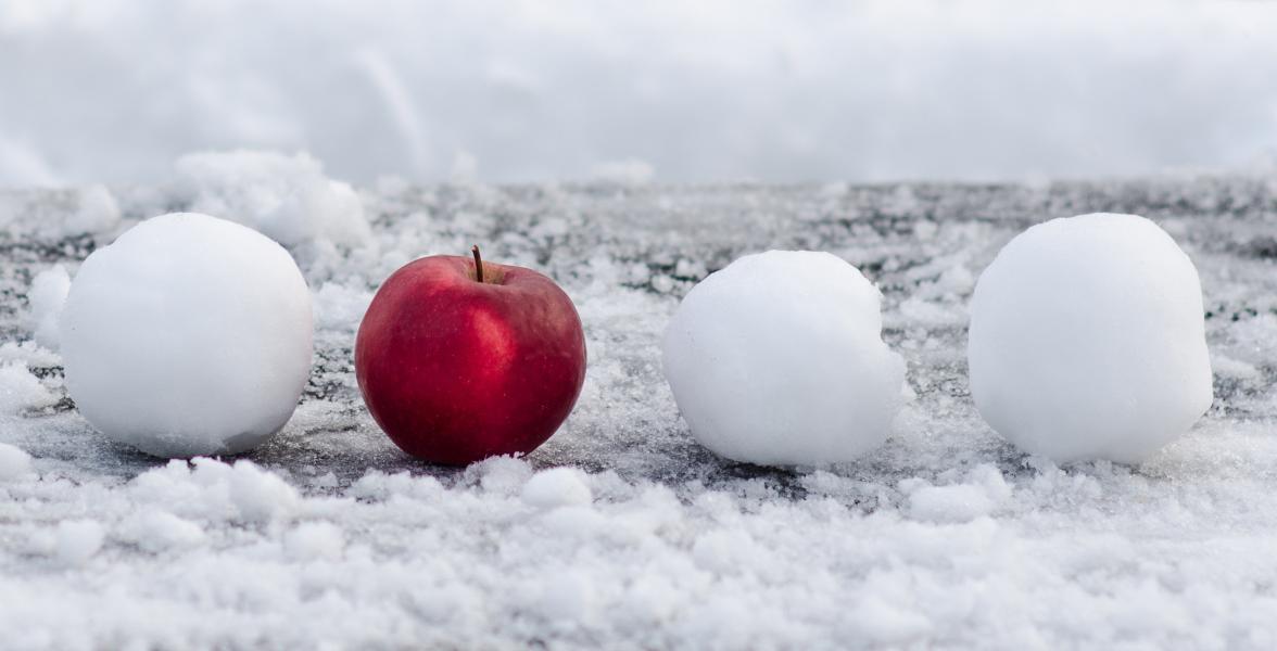 A snowball, a red apple and two more snowballs in a row.